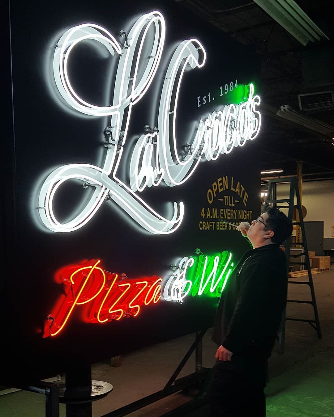 man workig on pizza neon sign